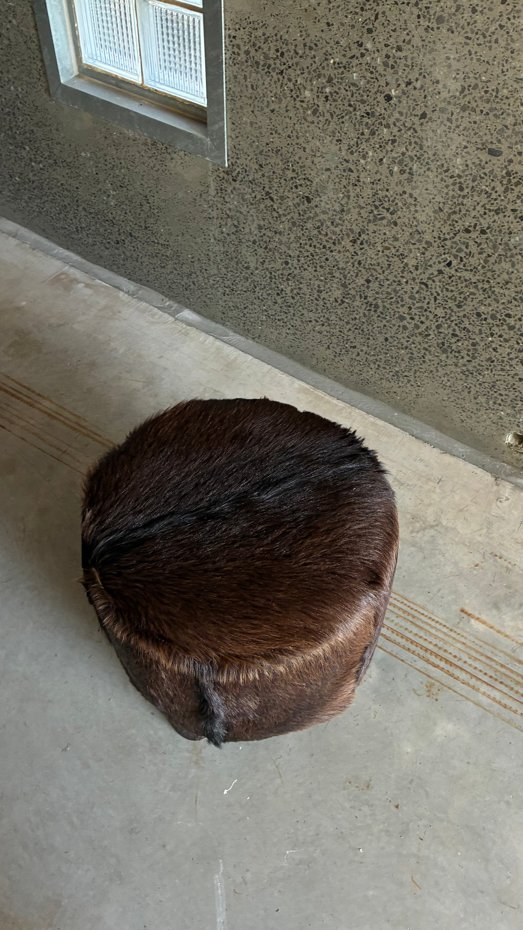 Mid-century cow hide footstool with carved timber feet 1970s