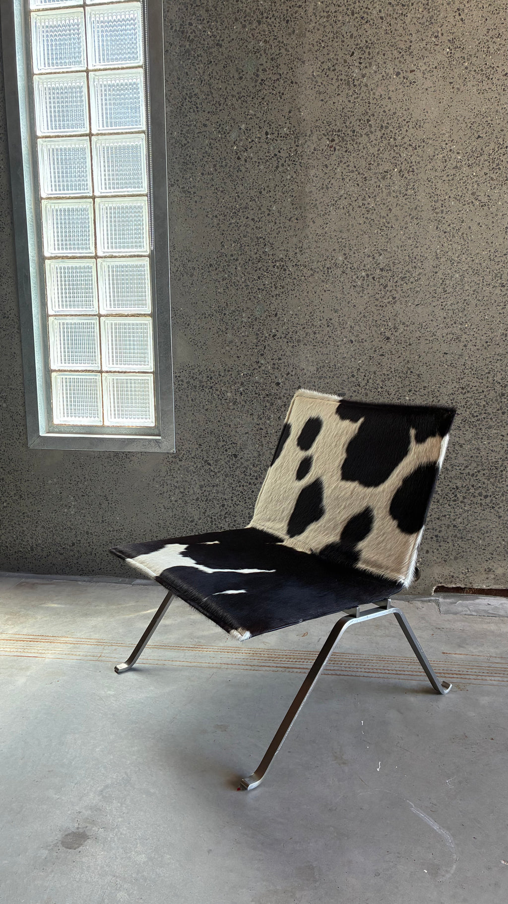 COWHIDE AND BRUSHED STEEL LOUNGE CHAIR