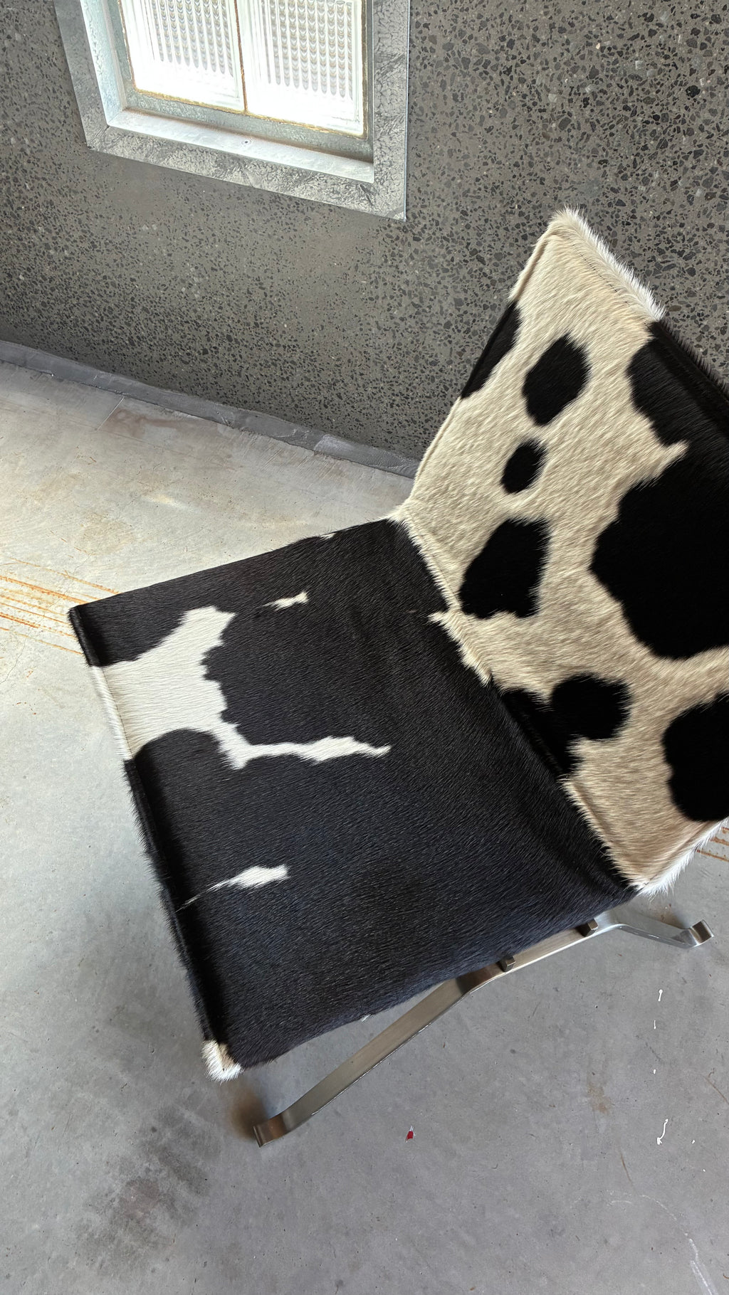 COWHIDE AND BRUSHED STEEL LOUNGE CHAIR